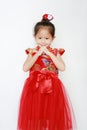 Happy little Asian child girl wearing red cheongsam with greeting gesture celebration for Chinese New Year isolated on white Royalty Free Stock Photo