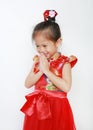 Happy little Asian child girl wearing red cheongsam with greeting gesture celebration for Chinese New Year isolated on white Royalty Free Stock Photo