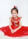 Happy little Asian child girl wearing red cheongsam with greeting gesture celebration for Chinese New Year isolated on white Royalty Free Stock Photo