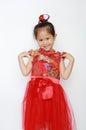 Happy little Asian child girl wearing red cheongsam with greeting gesture celebration for Chinese New Year isolated on white Royalty Free Stock Photo