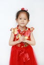 Happy little Asian child girl wearing red cheongsam with greeting gesture celebration for Chinese New Year isolated on white Royalty Free Stock Photo