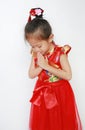 Happy little Asian child girl wearing red cheongsam with greeting gesture celebration for Chinese New Year isolated on white Royalty Free Stock Photo