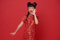 Happy Little asian child wearing traditional cheongsam qipao dress shout announcement Happy Chinese new year 2024 isolated on red