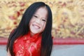 Happy little Asian girl in Cheongsam respecting on traditional Chinese new year festival on Chinese background