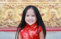 Happy little Asian girl in Cheongsam respecting on traditional Chinese new year festival on Chinese background