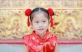 Happy little Asian girl in Cheongsam respecting on traditional Chinese new year festival on Chinese background