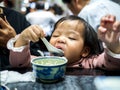 Happy Little asian girl eating rice by yourself at restaurant, Family concept Royalty Free Stock Photo