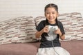 Happy little Asian girl playing video games with a joystick Royalty Free Stock Photo