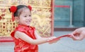 Happy little Asian girl received a red envelope. Chinese New Year celebration