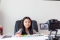 Happy little Asian girl sitting at the white table and live streaming for social media with happiness by camera select focus