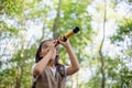 Happy Little Asian girls looking ahead and smiling child with the binoculars in the park. Travel and adventure concept. Freedom, Royalty Free Stock Photo