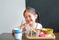 Happy little Asian kid girl eating rice by self in the restaurant Royalty Free Stock Photo