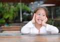 Happy little Asian kid girl lying on the wooden table Royalty Free Stock Photo