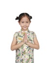 Happy little Asian kid girl wearing cheongsam with greeting gesture celebration for Chinese New Year Royalty Free Stock Photo