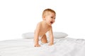 Happy little baby boy in diaper playing on bed, crawling, smiling  over white studio background Royalty Free Stock Photo