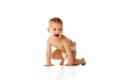 Happy little baby boy in diaper playing, crawling, smiling isolated over white studio background Royalty Free Stock Photo