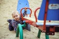 Happy little baby boy playing on the playground in the summer or autumn Royalty Free Stock Photo