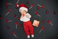 Happy little baby boy in Santa Claus hat smiling among Christmas candy canes Royalty Free Stock Photo