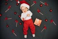 Happy little baby boy in Santa Claus hat smiling among Christmas candy canes Royalty Free Stock Photo