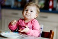 Happy little baby girl eating fresh croissant for breakfast or lunch. Healthy eating for children. Toddler child in Royalty Free Stock Photo