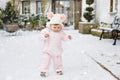 Happy little baby girl making first steps outdoors in winter through snow. Cute toddler learning walking. Child having Royalty Free Stock Photo