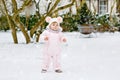 Happy little baby girl making first steps outdoors in winter through snow. Cute toddler learning walking. Child having Royalty Free Stock Photo