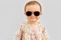 Happy little baby girl in sunglasses over grey Royalty Free Stock Photo