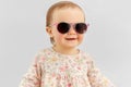 Happy little baby girl in sunglasses over grey Royalty Free Stock Photo