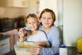 Happy little bakers. Portrait of two young siblings baking together at home. Royalty Free Stock Photo