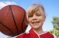 Happy little basketball player. A cute little girl holding a basketball and smiling at the camera. Royalty Free Stock Photo