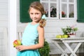 Happy little beautiful girl holds apple near white table