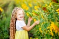 Happy little beautiful girl holds a sunflower in a field in summer Royalty Free Stock Photo