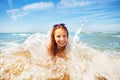 Cute girl being hit by a wave playing on sea beach Royalty Free Stock Photo