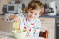 Happy little blond kid boy eating cereals for breakfast or lunch. Healthy eating for children in the morning. Child in Royalty Free Stock Photo