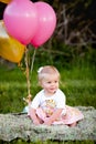 Happy little blonde caucasian girl outside with balloons