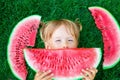 Happy little blonde girl lying on the grass with big slice watermelon in summer time Royalty Free Stock Photo