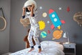 Happy little boy with astronaut helmet jumping on bed Royalty Free Stock Photo