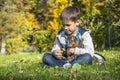 Happy little boy in the autumn park with pet kitten. Royalty Free Stock Photo