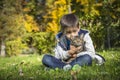 Happy little boy in the autumn park with pet kitten. Royalty Free Stock Photo