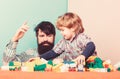 Happy little boy with bearded man dad playing together. father and son play game. building home with colorful Royalty Free Stock Photo