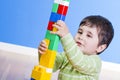 A happy little boy is building a colorful toy