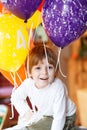 Happy little boy celebrating his 4 birthday with colorful balloons