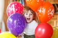 Happy little boy celebrating his 4 birthday with colorful balloons