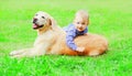 Happy little boy child and Golden Retriever dog is playing together on the grass on summer park Royalty Free Stock Photo