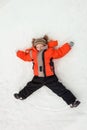 Happy little boy child laying on snow