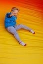 Happy little boy child rides on an inflatable multi-colored slide Royalty Free Stock Photo
