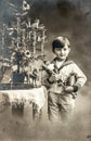 Happy little boy with christmas tree, gifts and vintage toys