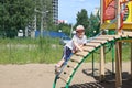 Happy little boy climbs on children playground