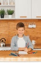 Happy Little Boy Does Homework, Writes Down Useful Information, Looks at Camera and Smiles. Distance Learning. Royalty Free Stock Photo