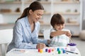 Happy little boy drawing picture with teacher at art school, developing creativity skills with paints, empty space